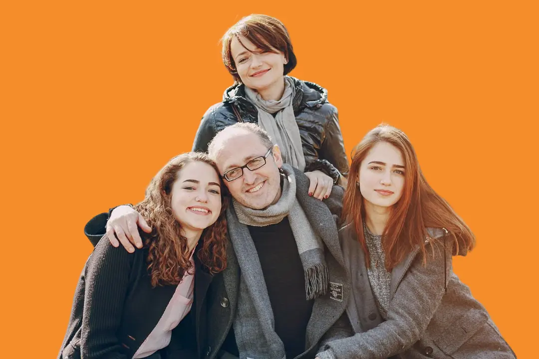 A group of four—two men and two women—smile together in front of an orange backdrop, with one person proudly displaying metal braces, at Levine Orthodontics in Fort Myers, Cape Coral or Lehigh Acres, FL.