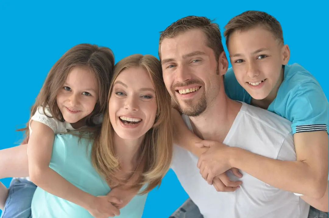 A family of four beams with bright smiles and clear braces, posing together against a solid blue background—an ideal reflection of happy patients at Levine Orthodontics in Fort Myers, Cape Coral or Lehigh Acres, FL.