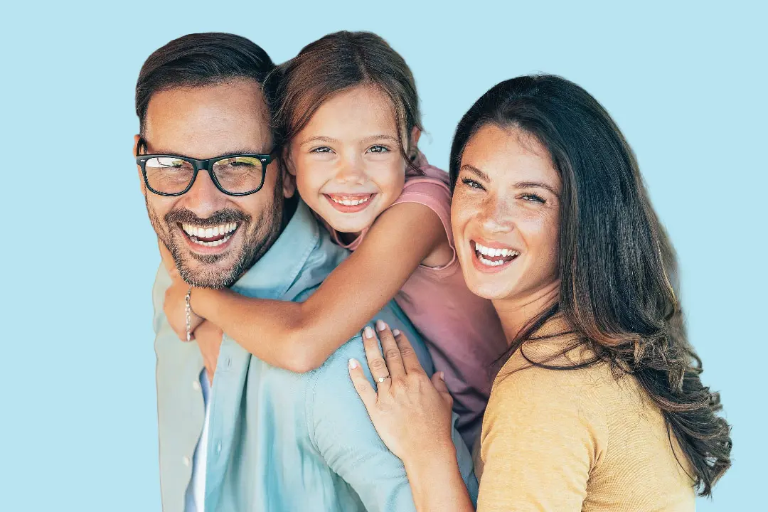 At Levine Orthodontics in Fort Myers, FL, a man carries a smiling young girl on his back while standing beside a woman, all facing the camera against a light blue background.