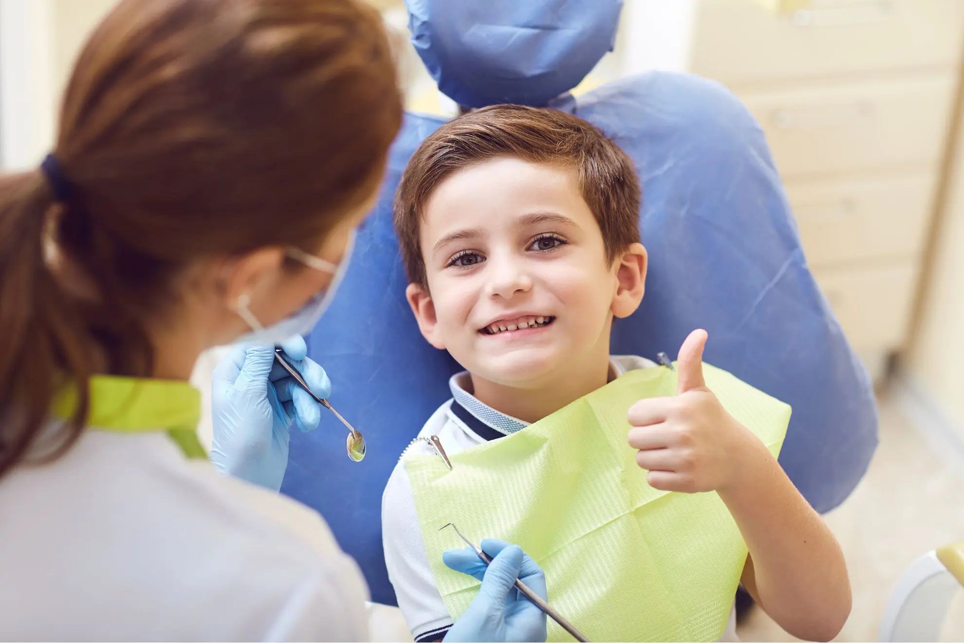 Smiling child at the dentist giving a thumbs up, excited to begin myofunctional therapy at Levine Orthodontics in Fort Myers, Cape Coral, and Lehigh Acres.