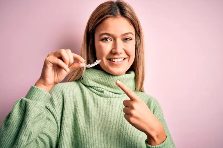 young beautiful woman holding invisalign clear aligners - Can Invisalign Fix Overbite in Fort Myers, Cape Coral, and Lehigh Acres, FL.